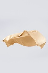 Beige silk pillowcase floating in air, smooth luxurious fabric, minimalist composition on light background, concept of elegance, softness and premium bedding.
