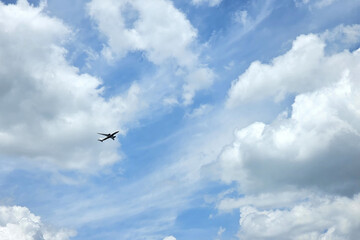Airplane Flying against Partly Cloudy Blue Sky.