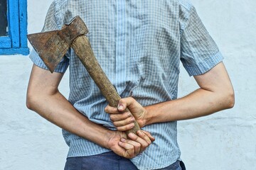 one iron rusty old retro wooden handle sharp industrial axe in hands of aggressive man from behind...