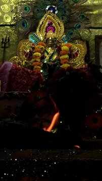 Hindu goddess Durga statue with traditional holy fire infront of statue. Religious concept for Dussehra, Dasara, Durga Puja, Vijayadashami, Navratri, Durga Puja, Diwali, Vertical. Focus On Foreground