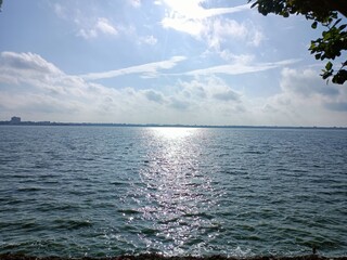 Sunlight Glinting on Rippling Lake Water Under a Cloudy Sky