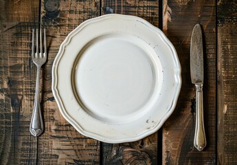 Rustic dining arrangement featuring a plate, fork and knife on aged wood
