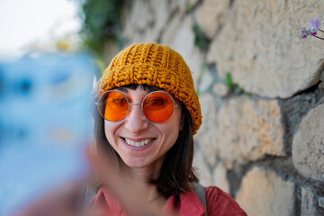 Woman taking photos on the street with a mobile phone. Stylish girl with a phone.