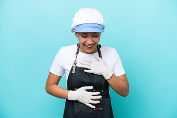 Fishwife Argentinian woman isolated on blue background smiling a lot