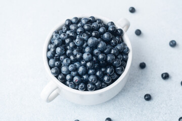 Blueberries in white bowl with soft cloth for comfort, diet or organic eating concept