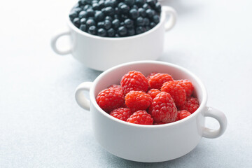 Bowls of raspberries, blueberries and cherries for fruit trio, diet or nutrition concept