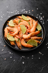 Close-up of cooked shrimp with lime wedges in bowl for gourmet seafood or fine dining concept