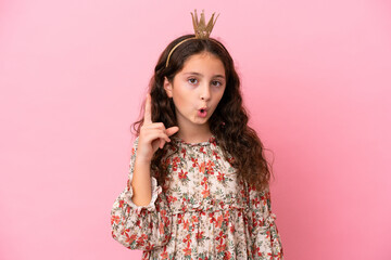Little caucasian princess with crown isolated on pink background intending to realizes the solution...