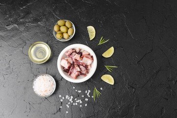 Octopus with olives, oil and salt on black background for gourmet ingredient or rustic cooking concept