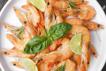 Shrimp with herbs and coarse salt on black surface for cooking background or seafood concept