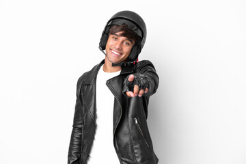 Young man with a motorcycle helmet isolated on white background pointing front with happy expression