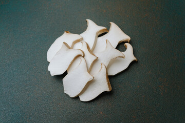 Sliced king oyster mushrooms on dark background for healthy cooking or vegan recipe ingredients