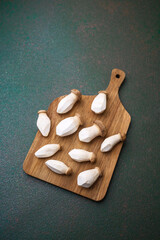 Raw king oyster mushrooms arranged on wooden cutting board for fresh vegetable or natural product...