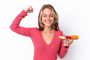 Young Russian girl holding sashimi isolated on white background doing strong gesture