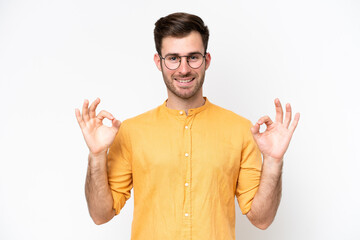 Fototapeta premium Young caucasian man isolated on white background showing ok sign with two hands