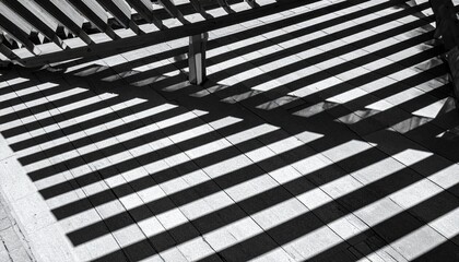 Abstract black and white pattern of overlapping wooden slats and their shadows.