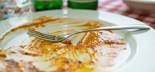 empty plate with fork  dirty of tomato sauce