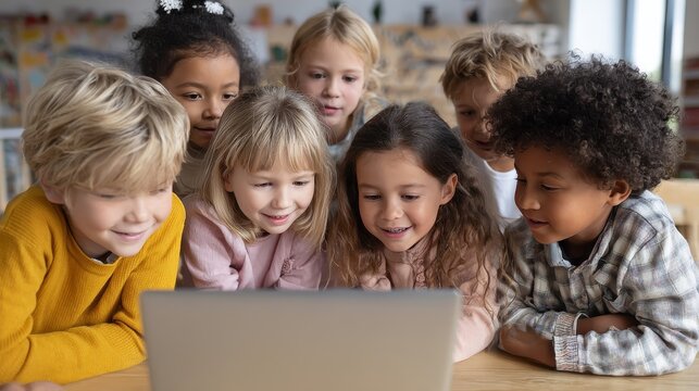 Diverse happy school kids using laptop computer together in classroom. Multicultural children junior students classmates learning online elementary education program class gathered at desk., no logos