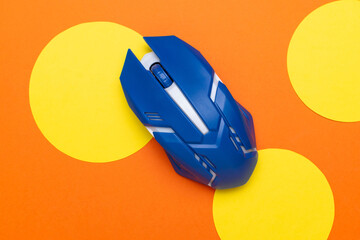 Blue Gaming Mouse on Vibrant Orange Background with Yellow Circles - Modern Tech Design