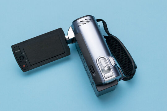 Vintage Silver Camcorder with Flip-Out Screen on Minimalist Blue Background