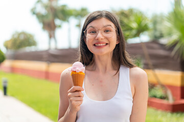 Young pretty Ukrainian woman with a cornet ice cream at outdoors with surprise and shocked facial...