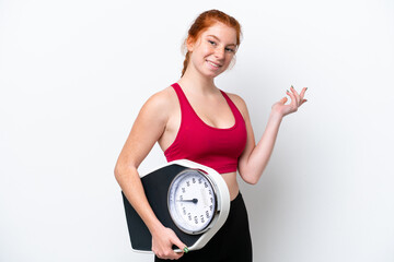 Young reddish woman isolated on white background with weighing machine