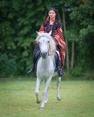 Asian Teen Tourist Girl Enjoys Horseback Riding in Modern Hill Tribe Costume in Chiang Mai,...