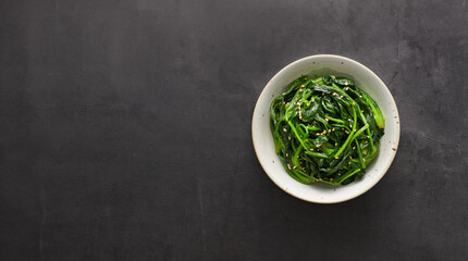 Japanese Spinach Salad with Sesame Dressing, Gomaae, on black background, top view, copy space
