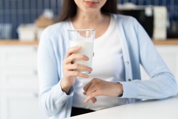 Close-up woman a glass of drink milk in the morning