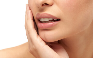 Obraz premium A close-up beauty photograph of a person's lower face and hand against a white background.