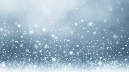 Falling snow against a cool blue background with a soft blurry effect