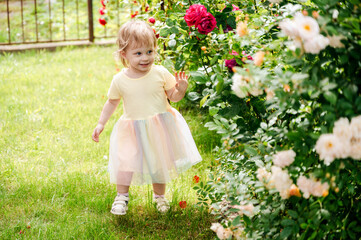 girl in dress walking in rose garden