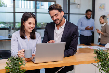 team of multiethnic colleague discuss business topic in creative green office co working space, group of business people coworker casual online meeting on laptop standing desk modern office workplace