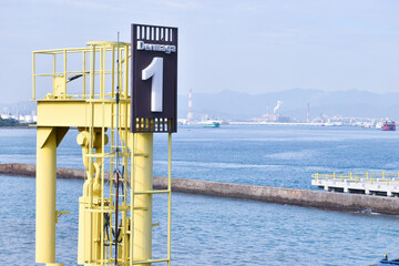 "Yellow Dock 1 at Merak Port, Cilegon, Banten, Indonesia, set against calm blue sea and distant industry. Vivid maritime scene blending modern port structure with scenic coastal backdrop."
