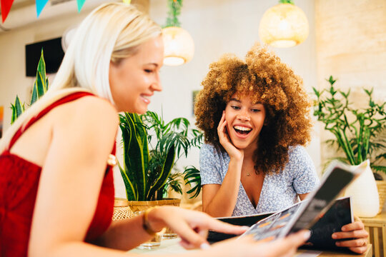 Two friends enjoying their time together, choosing from a menu in a brightly lit restaurant