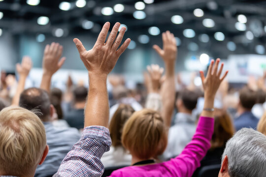 Audience actively participates in conference discussion by raising hands for questions