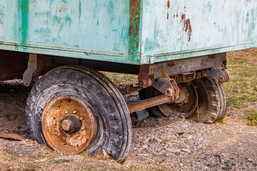 Rusty old trailer with partially visible wheels in rural setting