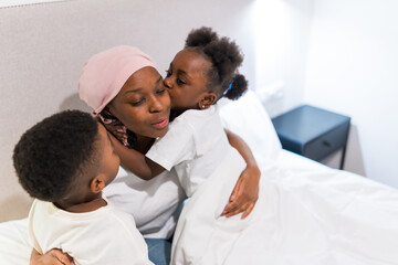 Fototapeta premium Children showing love and affection to their mother with cancer