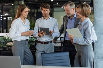 Group of business people standing together and discussing their work and projects, having a team...