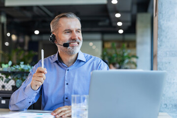 Smiling friendly handsome middle aged male call center operator.