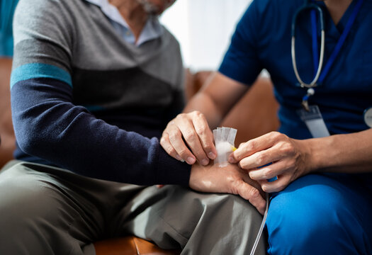 hand of physiotherapist change wound dressing or bandage for senior man to take care wound. home caregiver nurse visit retire couple for health check up recovery process medical service