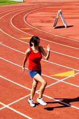 Young Hispanic Teen Woman In Blue Shorts And Red Top On Track