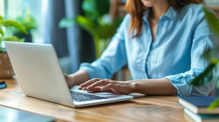Typing on Laptop at Desk with Plants and Books Indoor