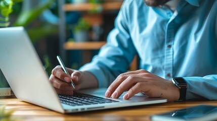 Person Working on Laptop, Using Pen for Notes or Input