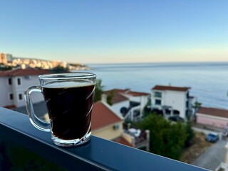 A glass of black coffee on a balcony in an apartment overlooking the Mediterranean Sea in Montenegro