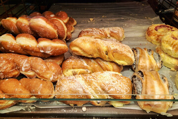 Delicious sweet pastries on display. Various glazed and sugared bakery items in a shop. Fresh baked...