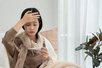Young Asian woman having high fever while checking body temperature, female sneezing and runny nose...