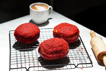 Delicious red velvet donuts on a white table. Red velvet doughnuts topped with cheese.
