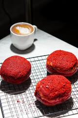 Delicious red velvet donuts on a white table. Red velvet doughnuts topped with cheese.