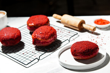 Delicious red velvet donuts on a white table. Red velvet doughnuts topped with cheese.